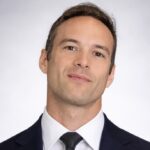 Professional headshot of man in suit and tie