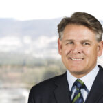 Smiling businessman in suit with city backdrop