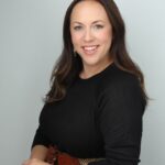 Professional headshot of smiling woman in black top