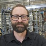 Man with glasses in industrial laboratory setting