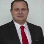 Man in black suit with red tie portrait