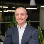 Smiling bald man in suit in office setting