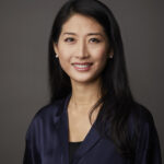 Professional headshot of smiling woman in navy blouse