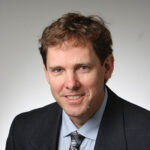 Man in suit and tie smiling headshot