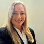 Smiling woman in business attire against plain background