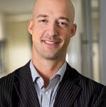 Smiling bald man in striped suit jacket indoors