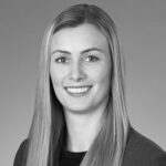 Black and white headshot of smiling woman in blazer