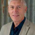 Portrait of gray-haired man in beige blazer