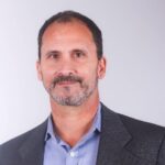 Man in blazer and blue shirt headshot