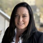 Smiling woman in black blazer outdoors