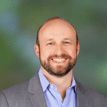Smiling bald man in suit and blue shirt