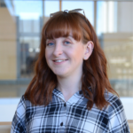 Smiling woman with red hair in plaid shirt
