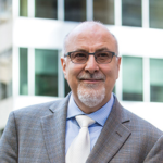 Smiling older man in suit outside office building