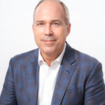 Professional headshot of man in blue blazer