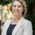 Smiling woman in beige blazer outdoors