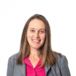 Smiling woman in gray blazer and pink blouse
