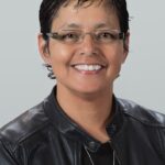 Smiling person wearing glasses and black leather jacket